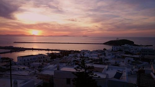 Scenic view of sea and town against sky during sunset