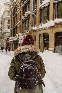 Rear view of people on street during winter