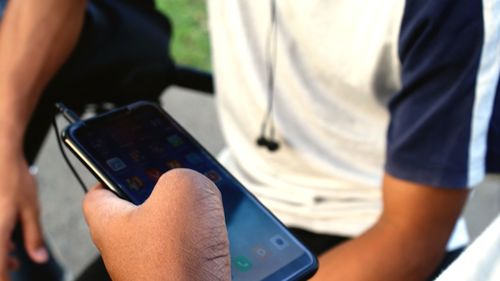 Cropped hand of woman holding smart phone