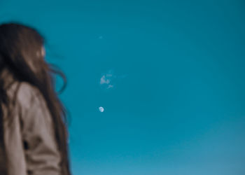 Rear view of woman against blue sky