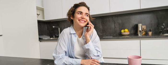 Young woman using mobile phone at home