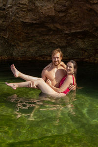 High angle portrait of man carrying woman in sea