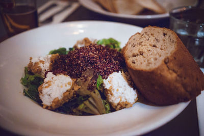 Close-up of bread and salad in plate on table