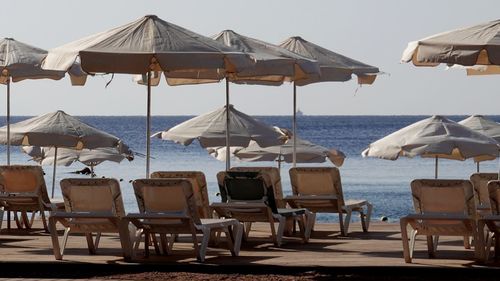 Chairs and parasols on beach against sea