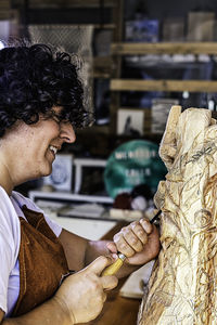 Sculptress carving wooden figure. first plane