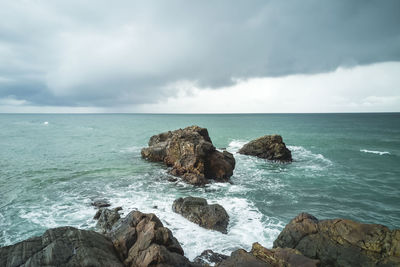 Rocks on sea shore against sky