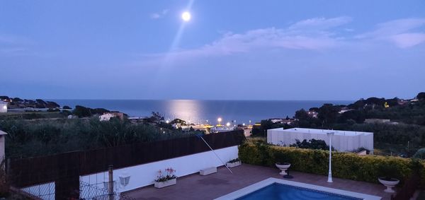 Panoramic view of swimming pool by sea against sky