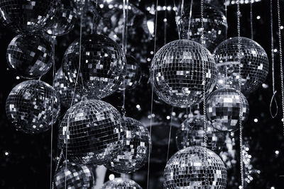 Close-up of hanging disco balls at night