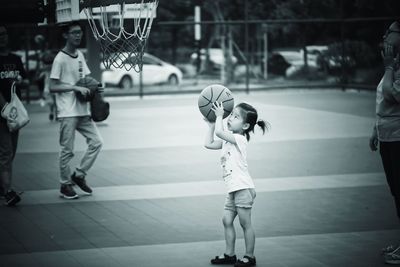 Rear view of people playing with ball