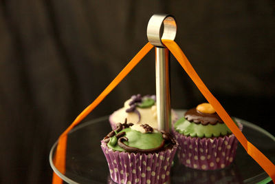 Close-up of halloween cupcakes on cakestand against black background
