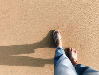 Low section of man lying on sand