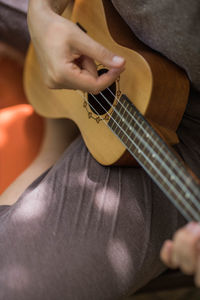 Cropped female hands playing the ukulele