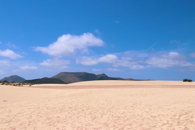 Scenic view of desert against blue sky