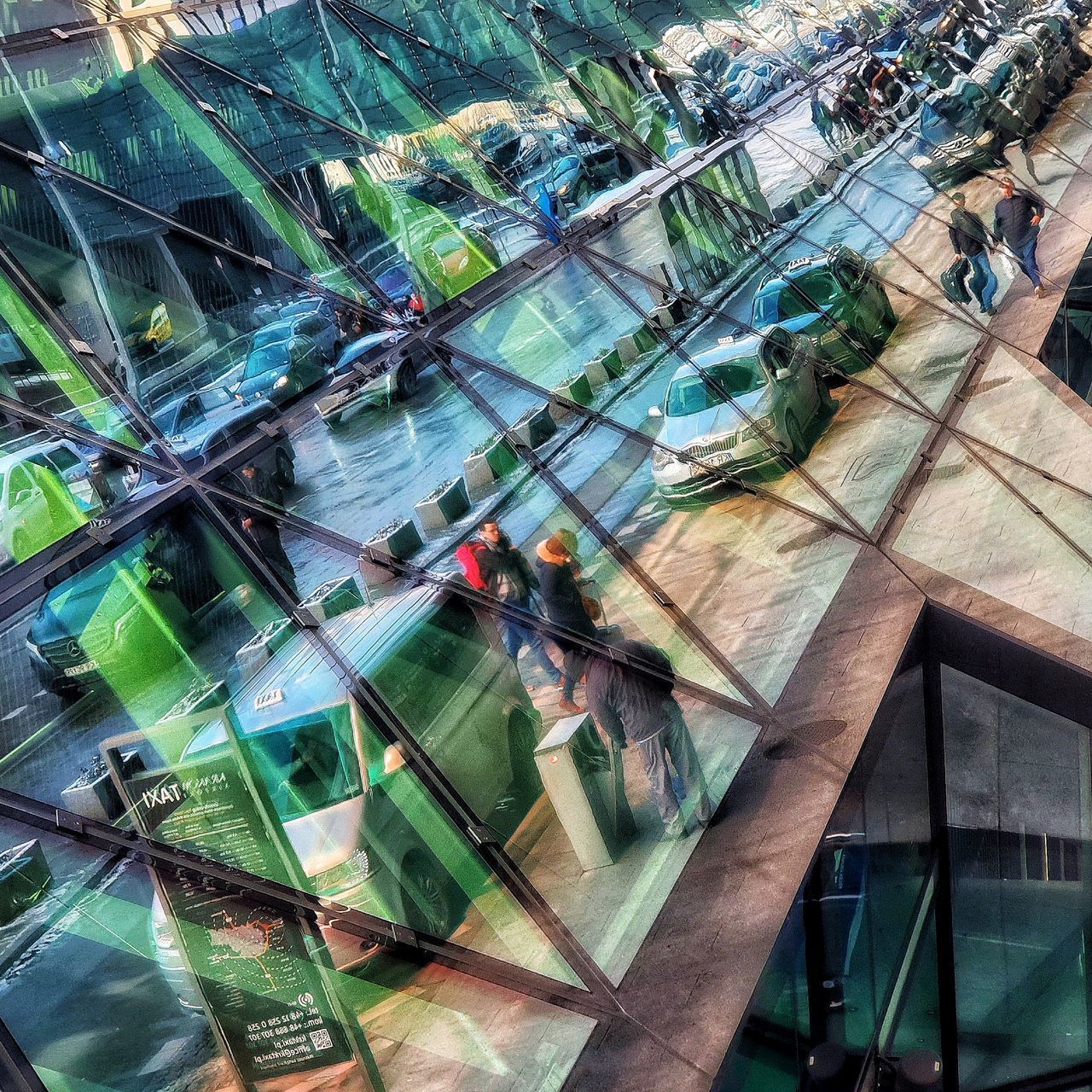 HIGH ANGLE VIEW OF PEOPLE WALKING THROUGH GLASS WINDOW