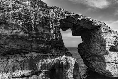 Rock formations by sea against sky