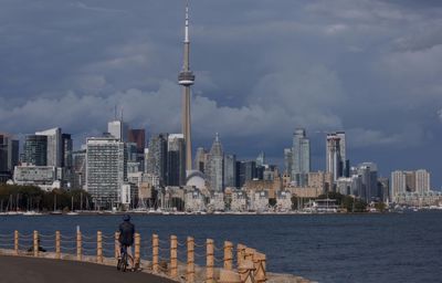 Modern buildings in city against cloudy sky