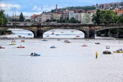 People on bridge over river in city