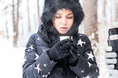 Portrait of woman holding ice cream in winter