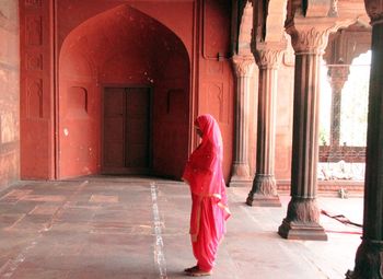 Midsection of woman against red building