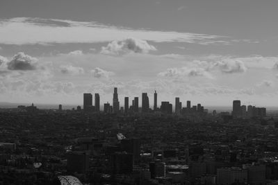 Aerial view of buildings in city against sky