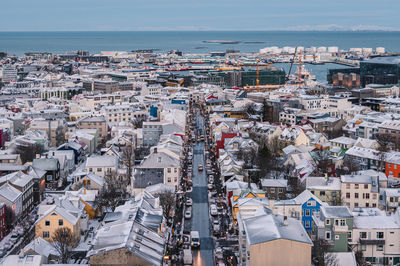 High angle view of townscape by sea against sky