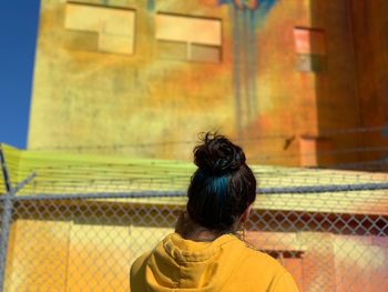 Rear view of woman looking at colorful building in city