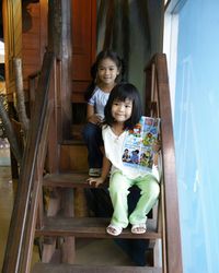 Portrait of girl sitting with sister on steps