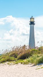 Lighthouse by sea against sky