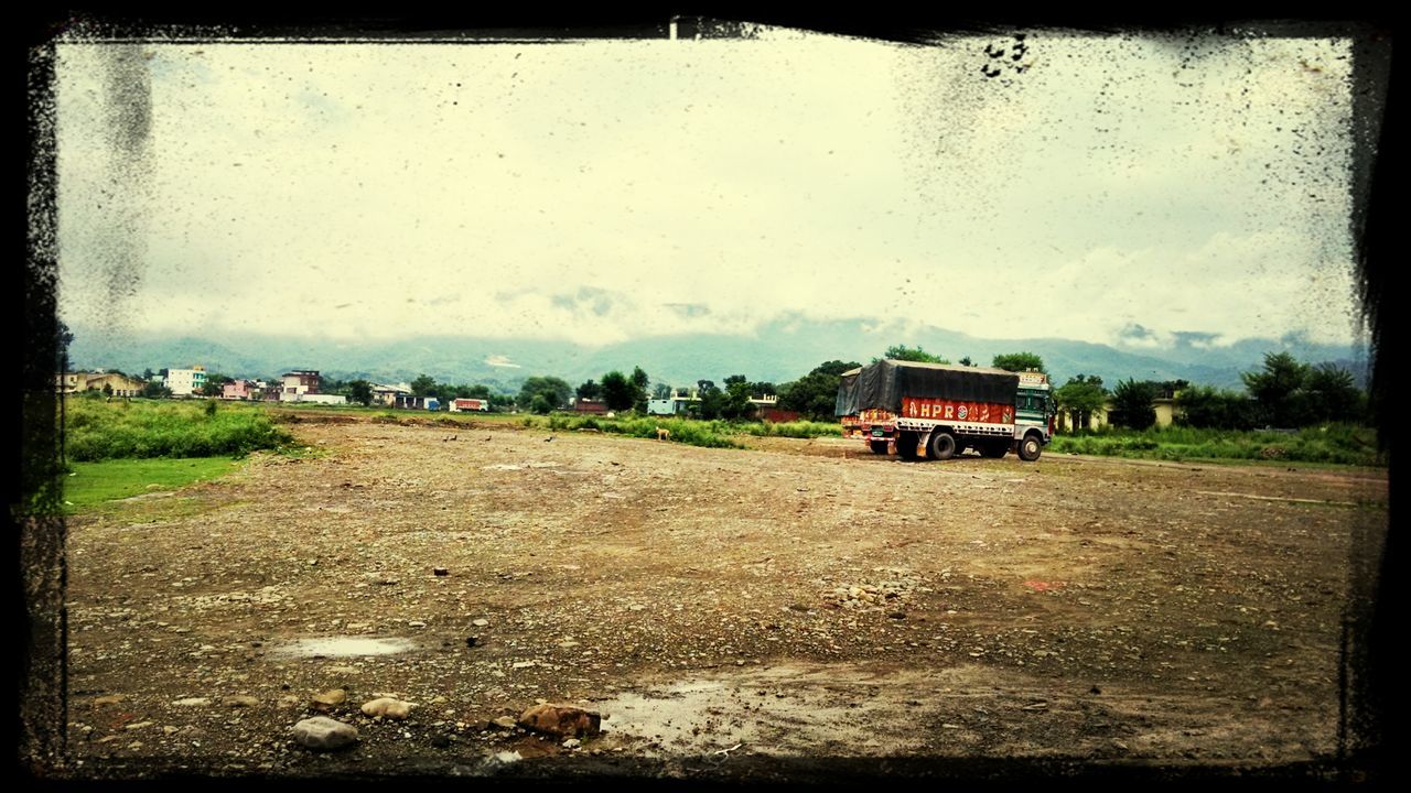 transportation, transfer print, mode of transport, auto post production filter, land vehicle, building exterior, sky, architecture, built structure, car, house, abandoned, day, road, street, outdoors, damaged, field, obsolete, no people