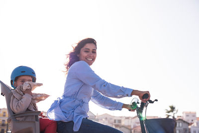 Portrait of smiling woman riding horse against clear sky