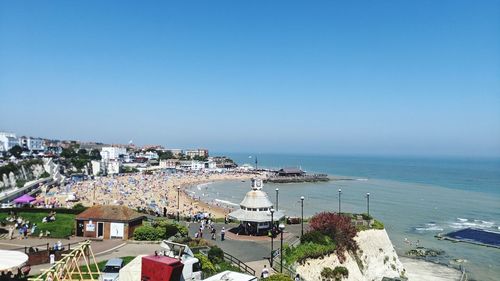 High angle view of buildings by sea against clear sky