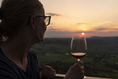 Woman tasting wine at sunset