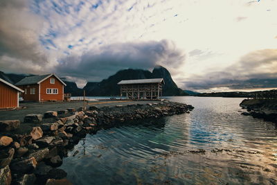 Buildings by sea against sky