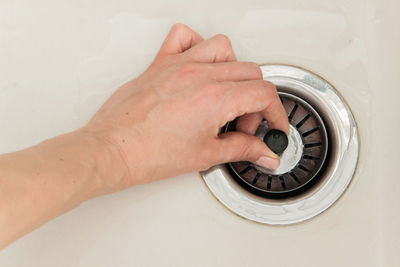 Close-up of woman holding drain of sink