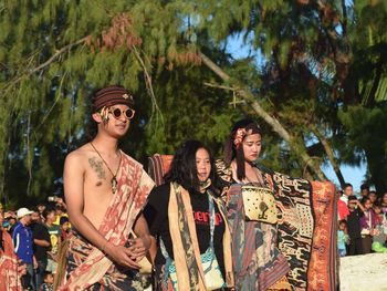 Young man and woman standing against plants