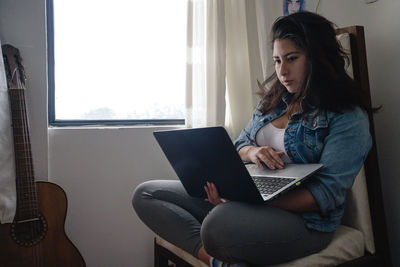 Young woman using mobile phone at home