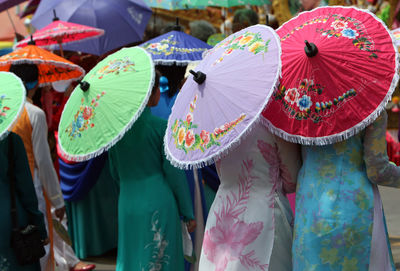 People with colorful japanese umbrellas on street