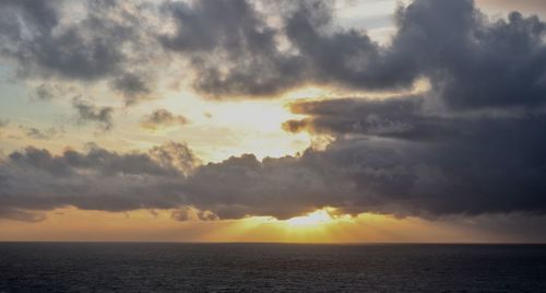 Scenic view of sea against dramatic sky during sunset