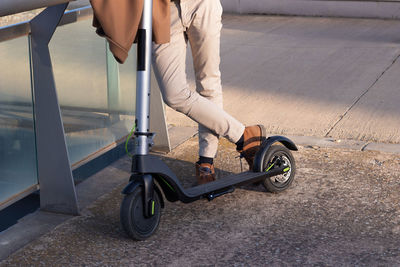 Cropped view of unrecognizable man leaning with his electric scooter for commuteing to work 