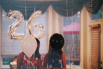 Friends covering their face with balloons