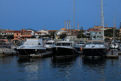 Boats in sea against clear blue sky