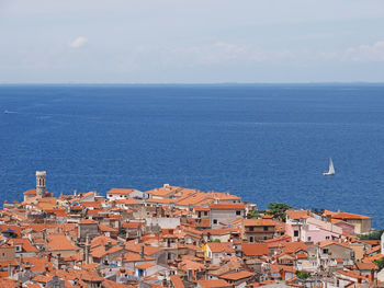 High angle view of townscape by sea against sky