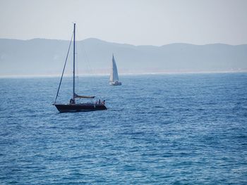 Sailboat sailing on sea against sky