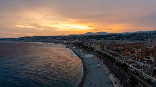 Panoramic view of sea and buildings against sky during sunset