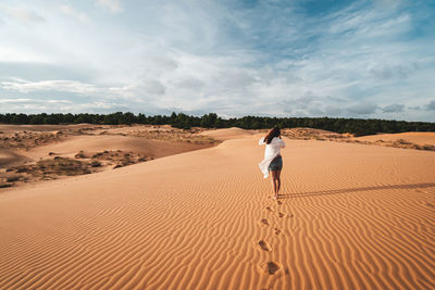Full length of man standing on sand dune