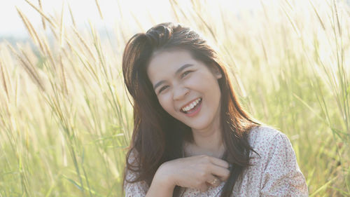 Portrait of smiling young woman lying on field