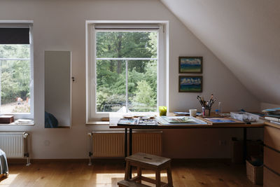 Paintings on table in front of window at home