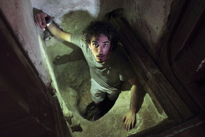 High angle view of young man exploring obsolete basement