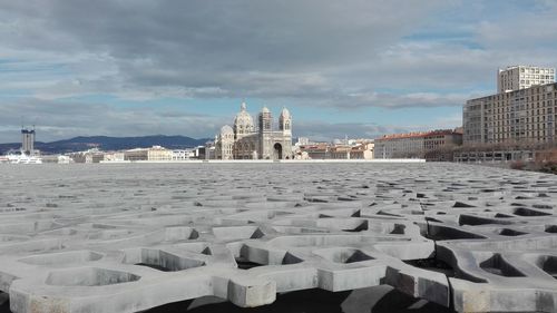 View of cityscape against cloudy sky