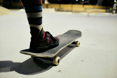 Young man with his foot on the skateboard to start skating